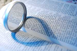 Bible with a magnifying glass on it, making a heart-shaped shadow