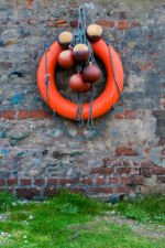 A lifebelt and floats hanging on a farmyard wall